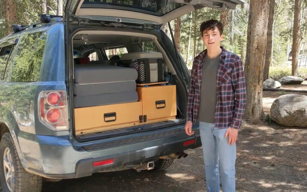 Sawyer showing his suv camper's outdoor kitchen