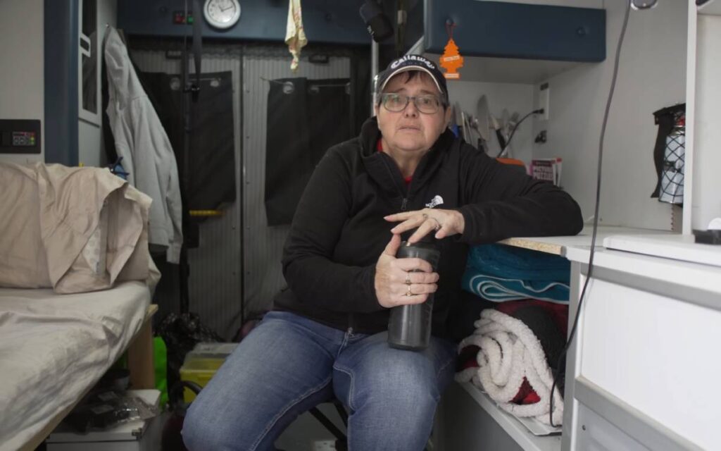 @nanbulance Woman holding a tumbler sitting inside her ambulance conversion van