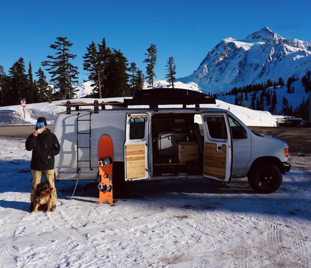 @nate_n_niko ford econoline camper parked on roadside against beautiful snow mountain