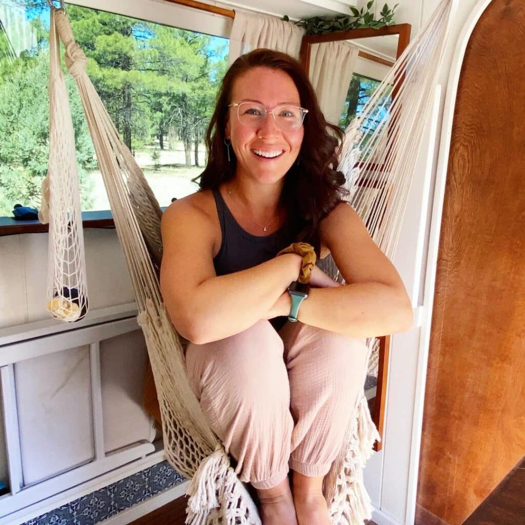 @theroadthroughmyeyes Woman sitting in a hammock inside a ford econoline camper