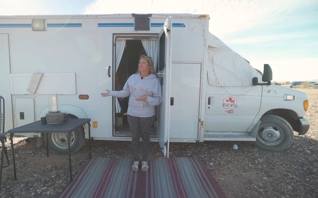 @van_vida_travels Woman standing next to a white camper van ambulance