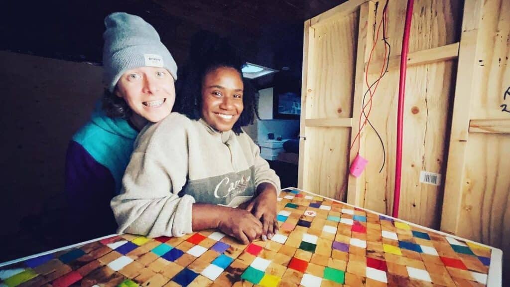 @canadianstealth Young couple smiling at the camera  inside a box truck camper