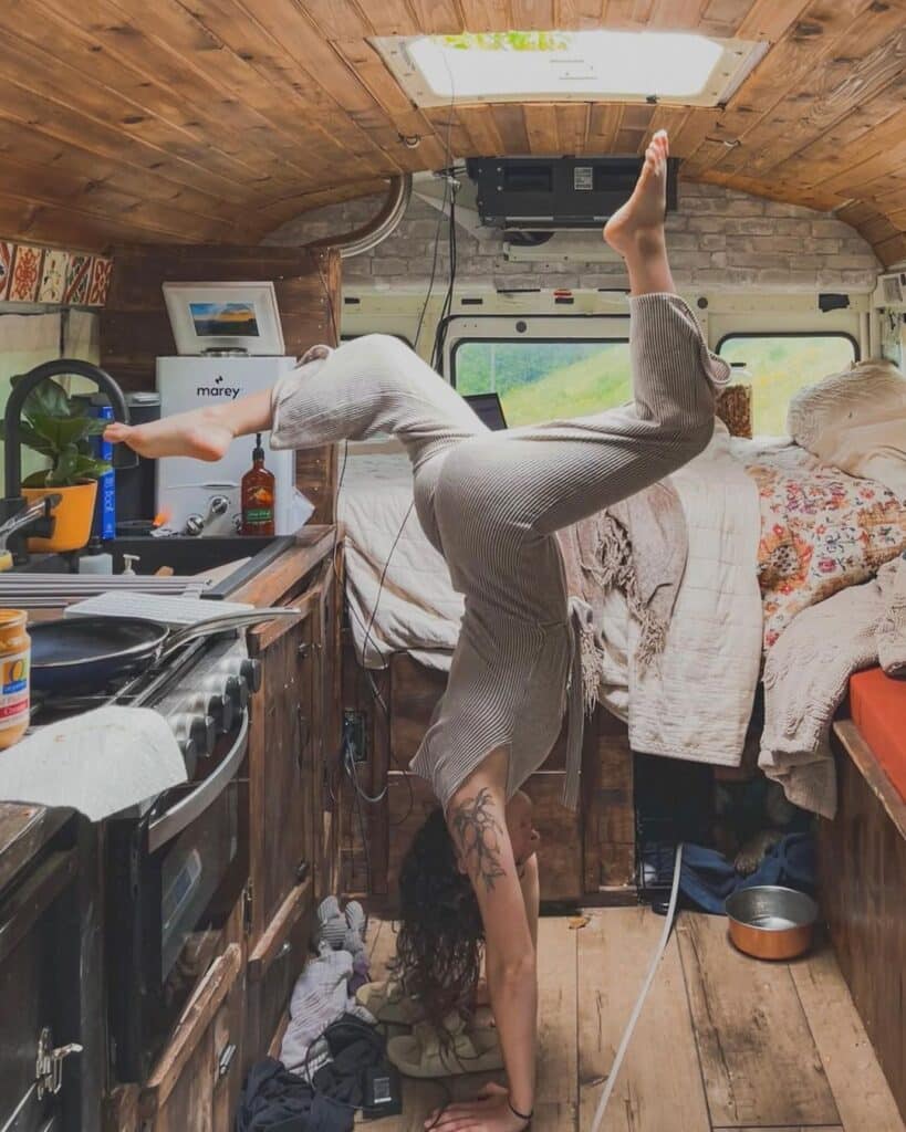@ilariamorris Young woman doing handstand inside her small bus rv
