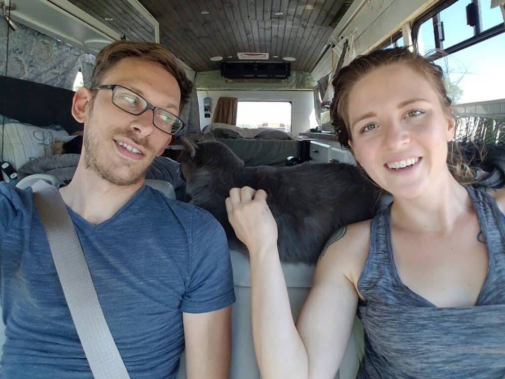 @livingzeal Smiling young couple sitting at the front seat of a short bus conversion