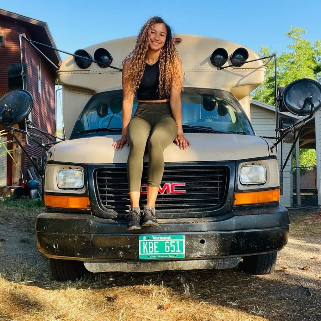 @the.skoolie.teacher Woman sitting on the hood of a short bus conversion
