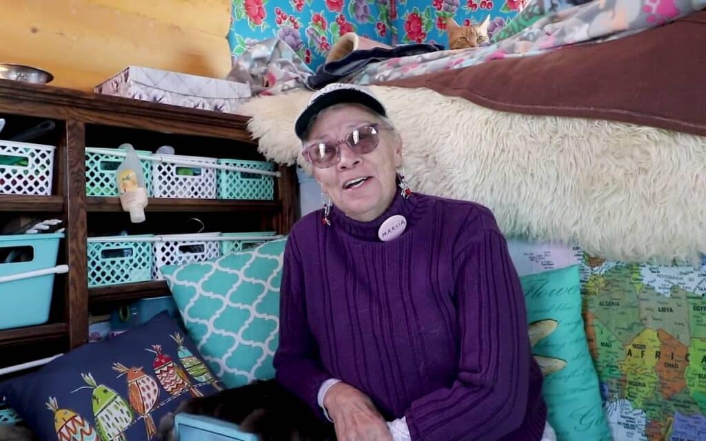 Marcia sitting on a couch in her box truck camper