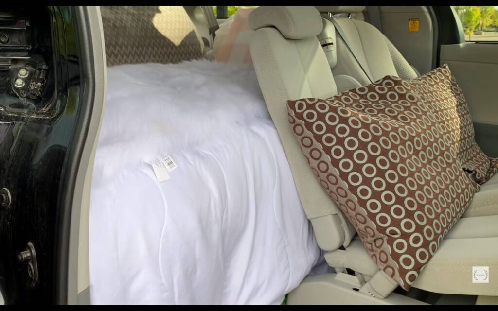 @lifesimplifiedbymai A bed behind the driver's seat inside a Toyota Sienna camper