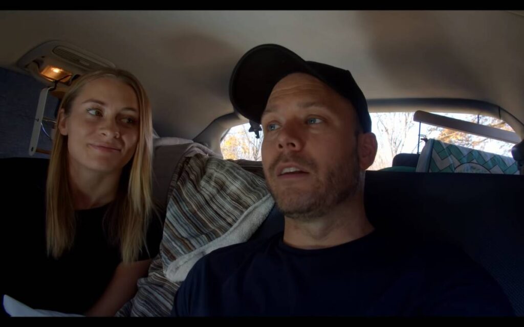 @thegymnomads Chris and Emelia sitting in their camper, and talking about their Toyota Sienna microcamper conversion