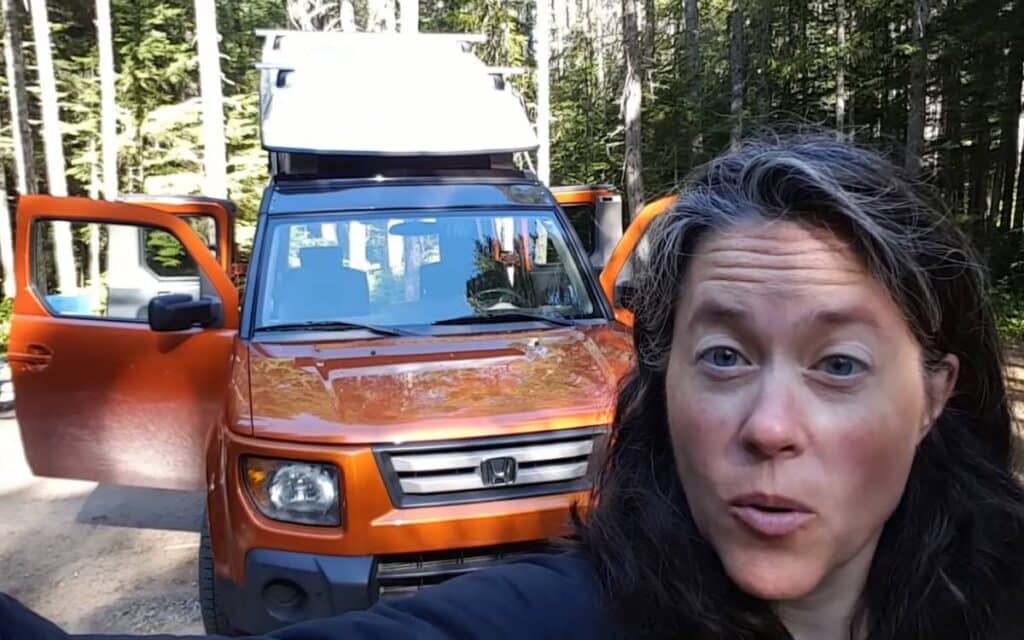 Charis showing her honda element camper with a pop-up tent