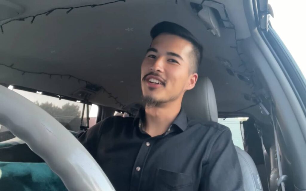 Jimmy sitting in the driver's seat of his Toyota Sienna camper