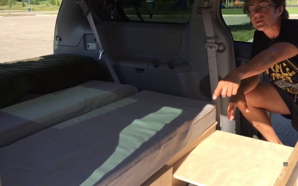 Kelly showing her Toyota Sienna camper conversion bed system