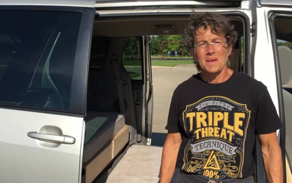 Kelly standing near her Toyota Sienna camper