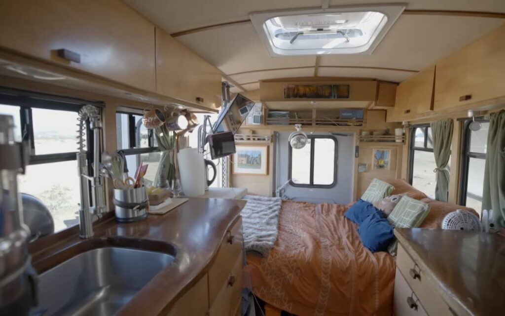 @wanderbooming bed and kitchen inside Eric and Robbyn's shuttle bus conversion