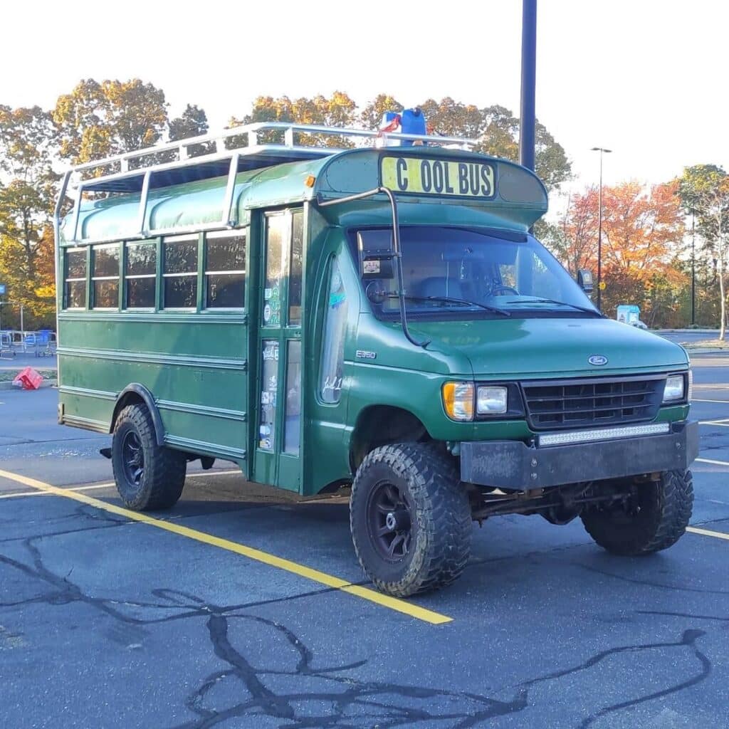 A green four-wheel drive vehicle parked at a parking lot