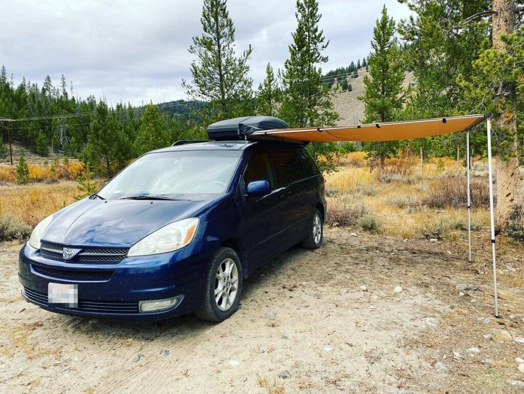 Blue Toyota Sienna parked in the forest