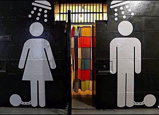 Huge male and female shower sign painted on black wall