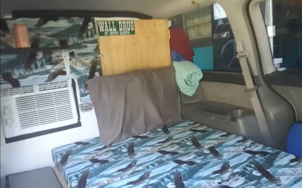Kathy's campervan bed next to an AC