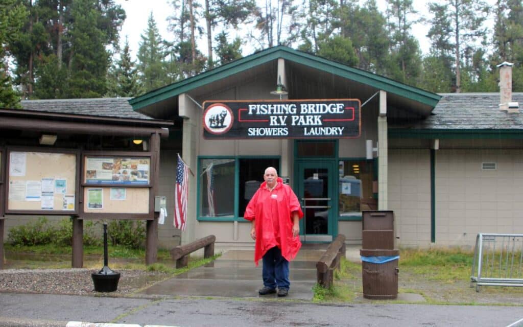 Old man standing in front of a campground shower and laundry building