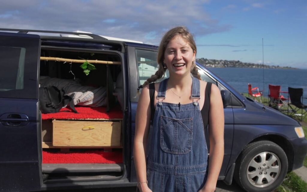 Sarah smiling while standing next to her minivan camper