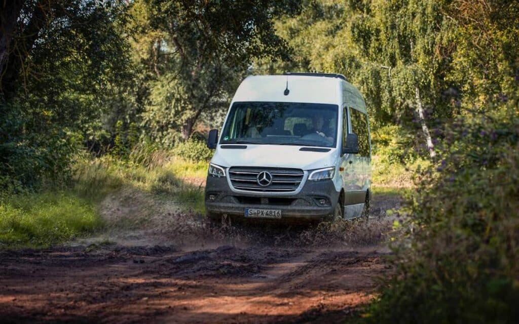 White Mercedes Sprinter van running on muddy road