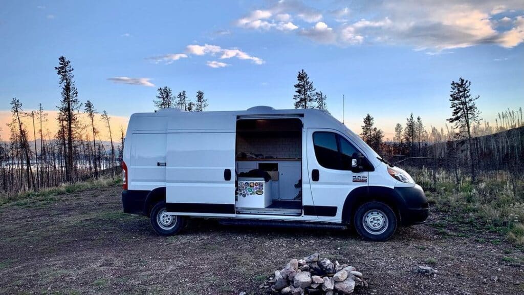 White Promaster campervan parked near a lake