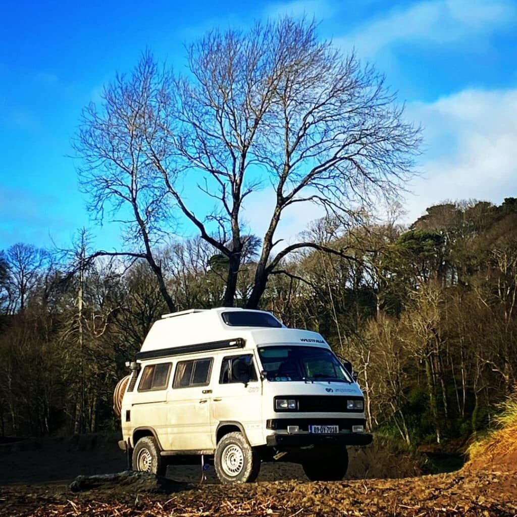 White van parked in the forest