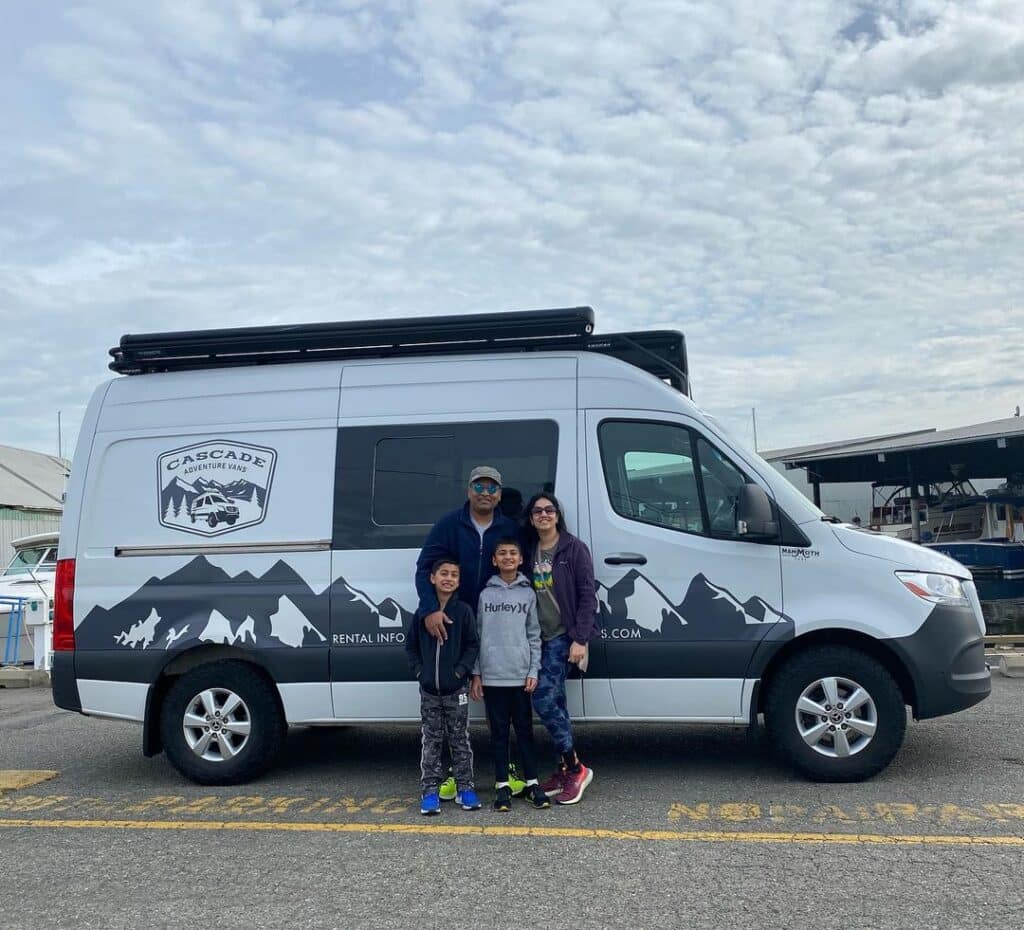 @cascadeadventurevans A happy family of four standing next to one of Cascade Adventure Vans campervan rentals campers
