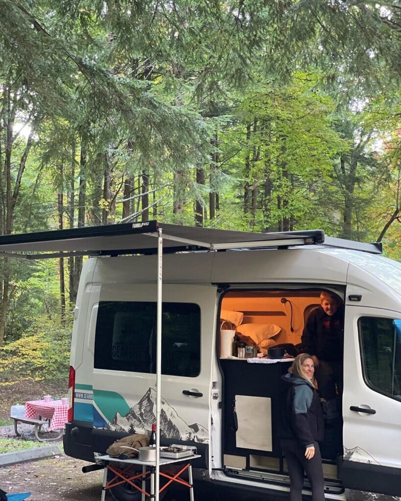 @gearbox_adventure_rentals Couple camping together in the forest with a campervan from Gearbox Adventure campervan rentals