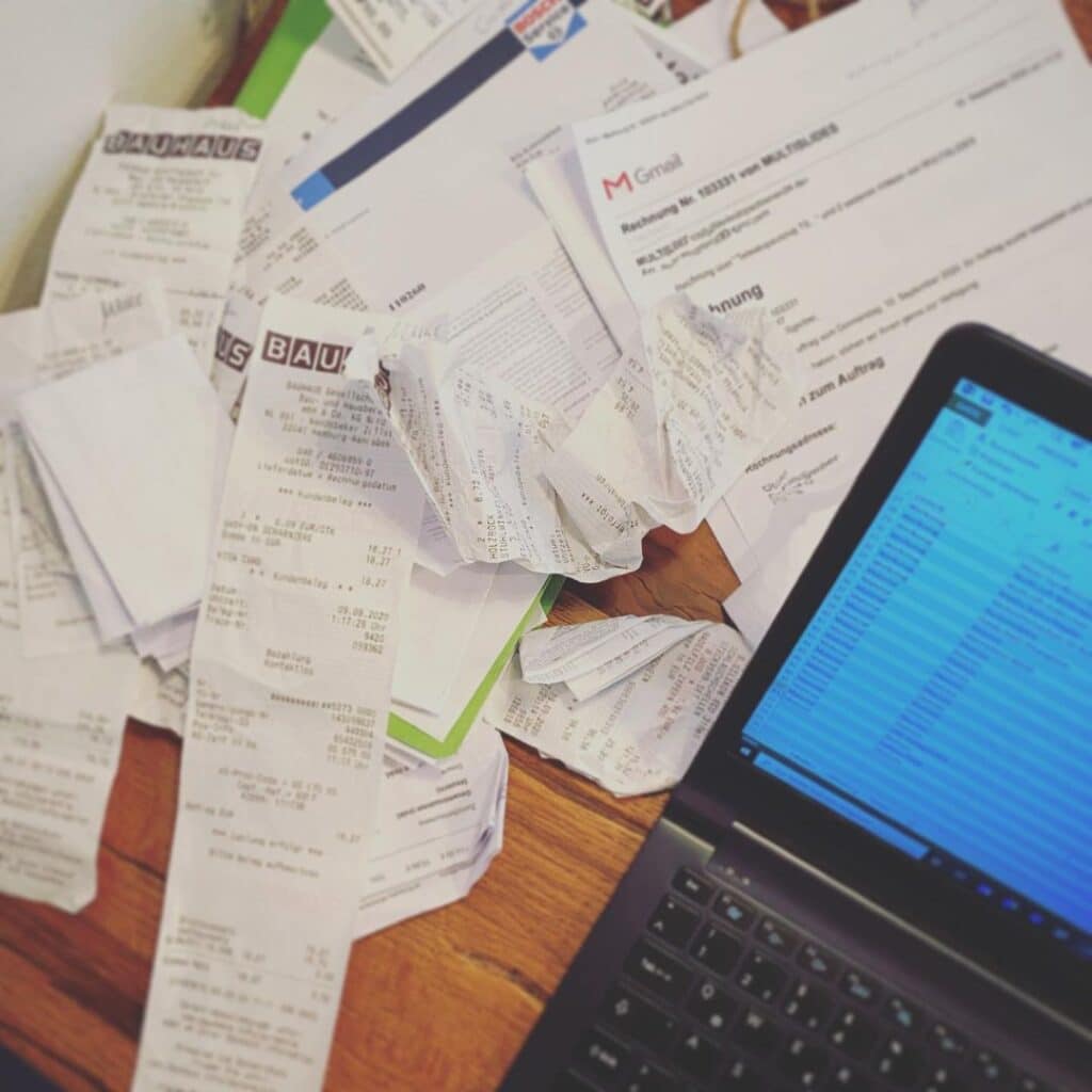 @knut.campervan Laptop and receipts on a wooden table
