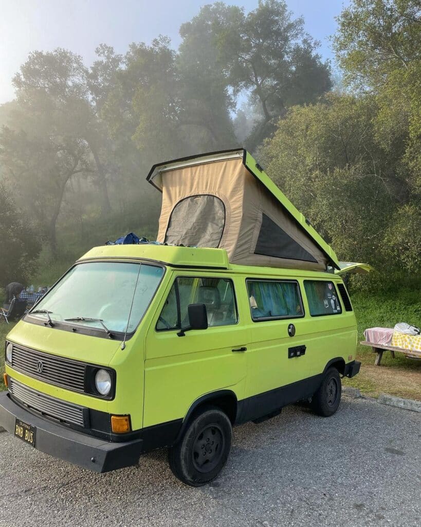 @kristin_youngs Green VW camper from camper van rental company Vintage Surfari Wagons parked near trees