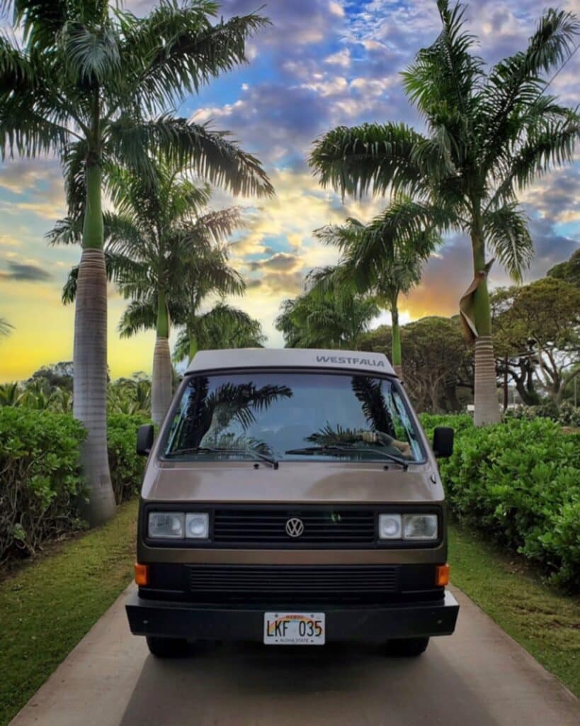 @mauiwesty campervan rentals camper parked in a parking space surrounded by tropical plants
