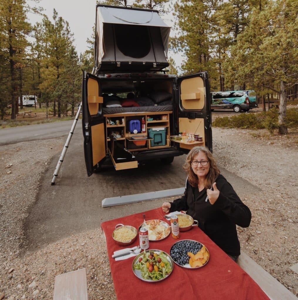 @nativecampervans campervan rentals, woman eating her meal outside her camper 