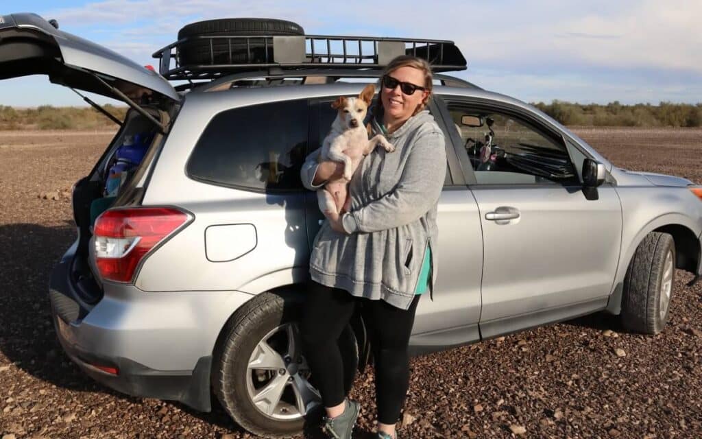 @popfizzpaper Dani holding her dog while leaning against her subaru forester camper conversion
