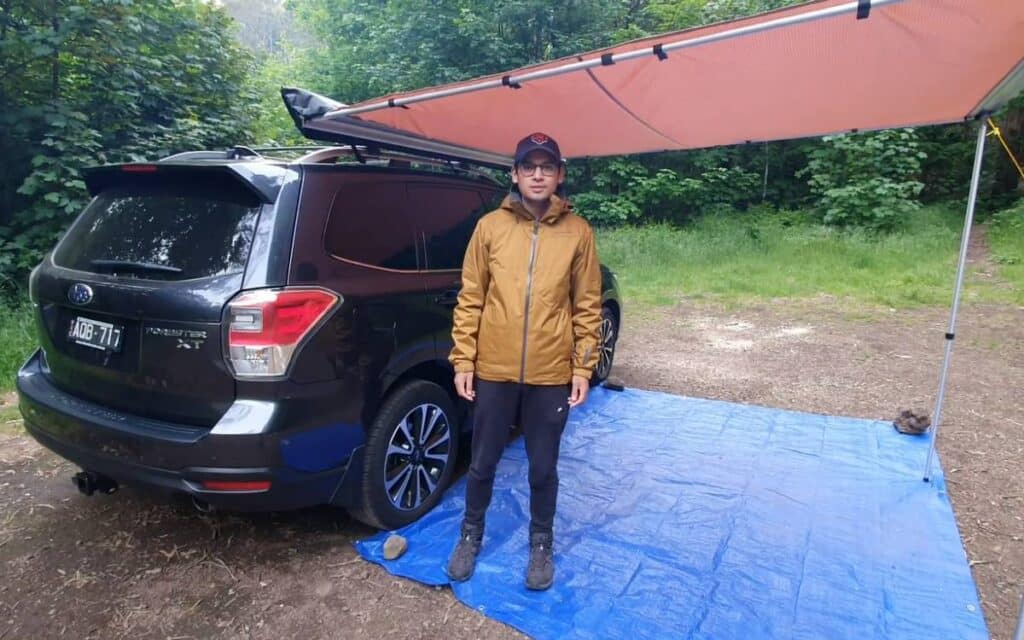 @regan7940 Regan standing next to his black subaru forester camper conversion with awning