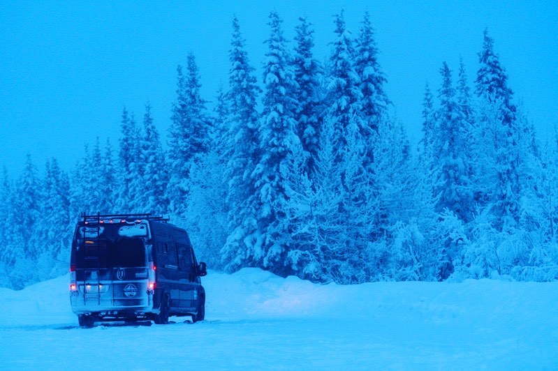 @riverwildcampervans campervan rentals camper near pine trees covered in snow