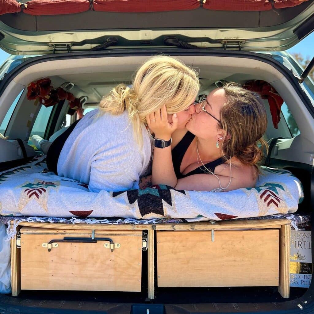 @twotravelingladies5786 Julia and Michaela kissing inside their forester camper