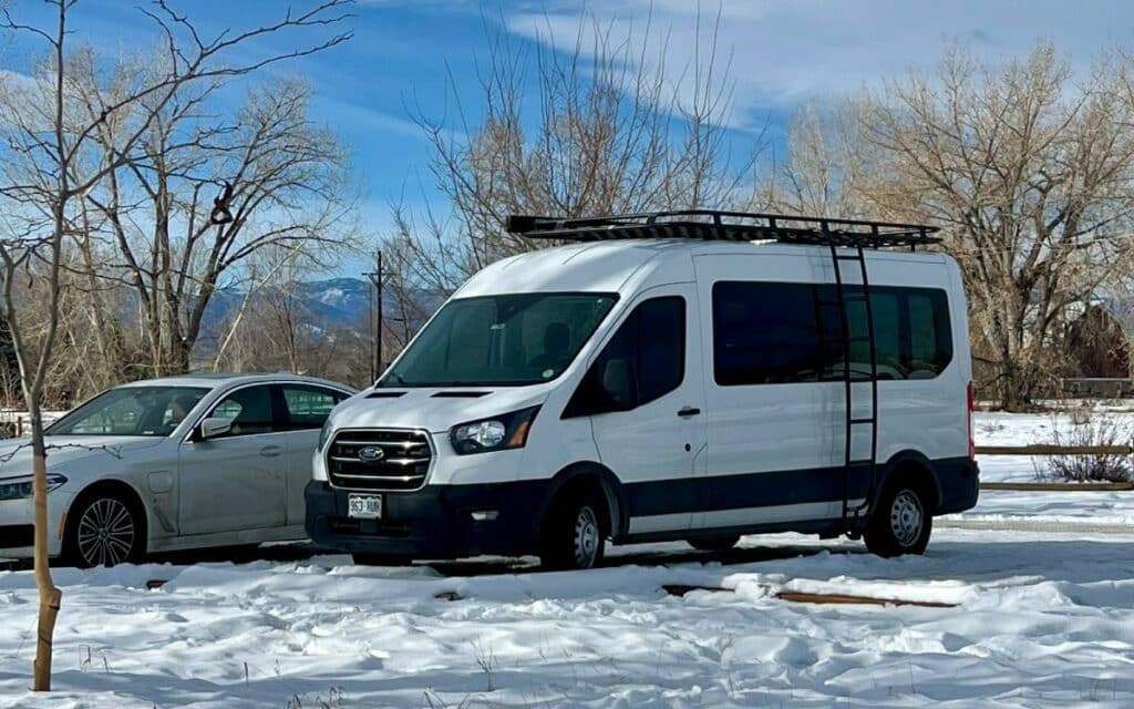 White ford transit van parked in snow in a parking lot