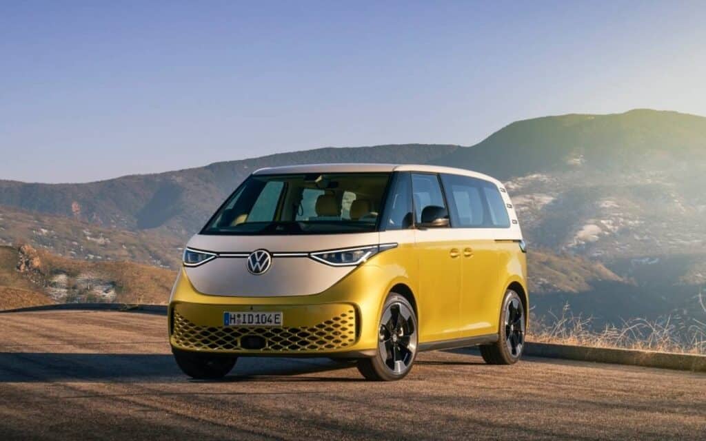 3D image of a yellow and white Volkswagen electric camper parked high in the mountains
