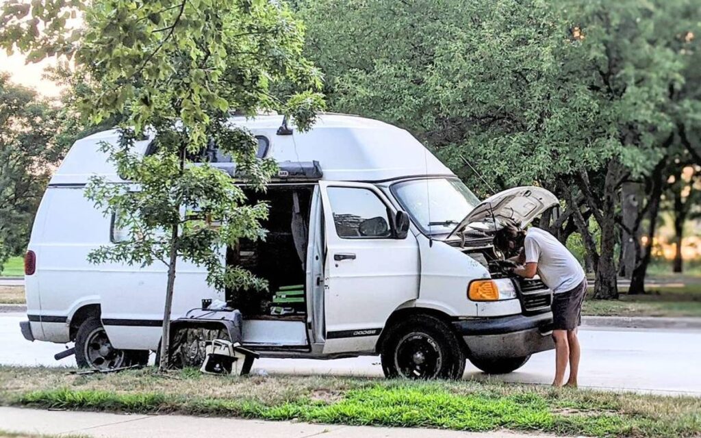 @photoslice Man repairing his campervan on the side of the road