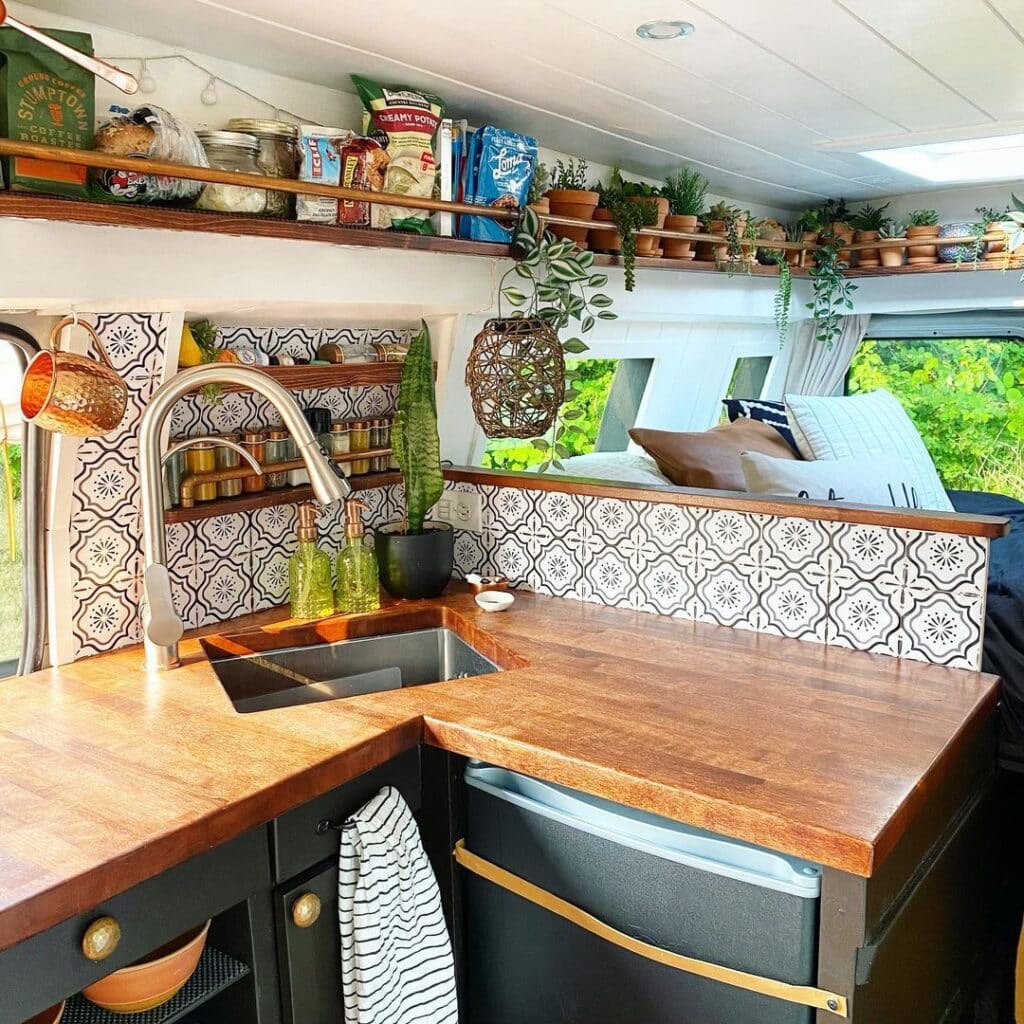 @theroadthroughmyeyes Camper interior with plants and kitchen storage organized neatly