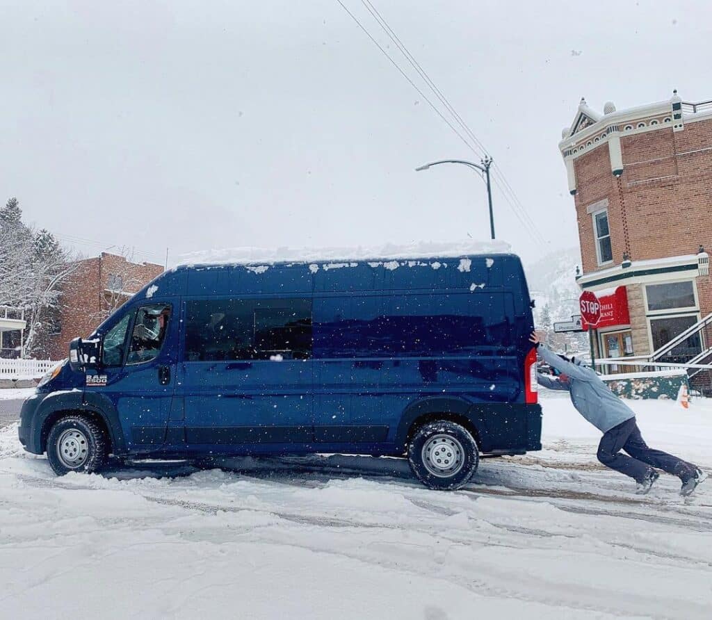 @tory.tory.r Man pushing a blue van stuck in snow