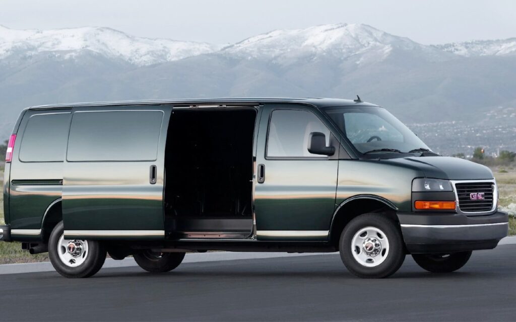 Black GMC vehicle parked on the road with mountain view background