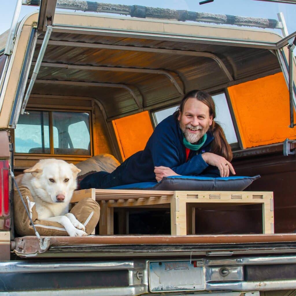 @campncar Vanlifer lying in his camper van bed next to his dog