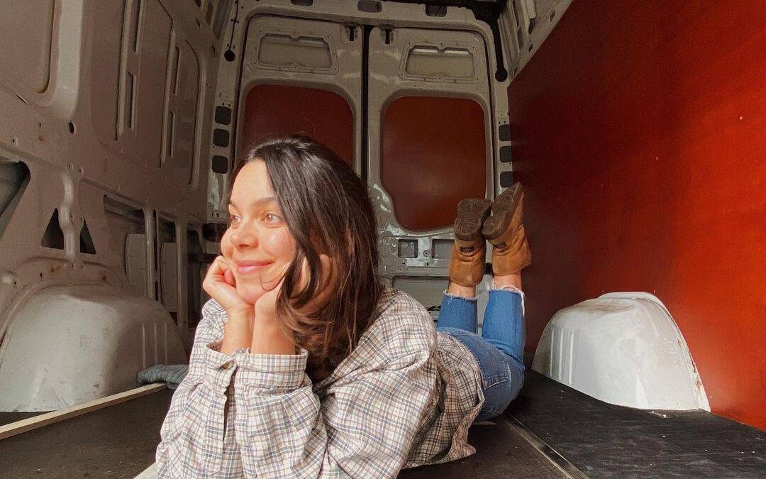 @daelgunterman Smiling woman lying on camper van floor, excited to build her camper van