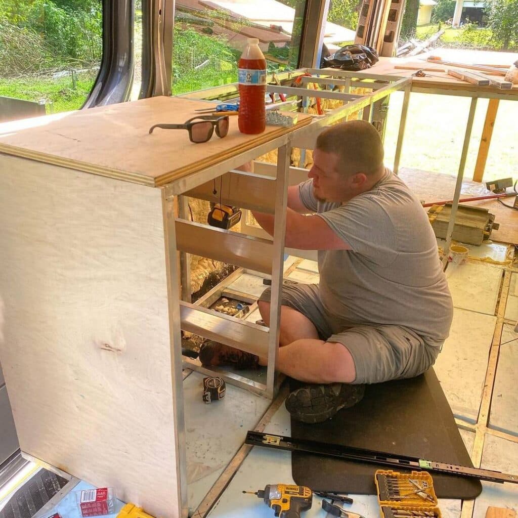 @everyvanhasahorn Man installing kitchen drawers inside his van