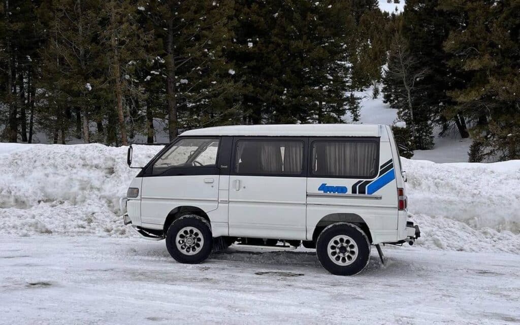 @lifewithdelica White Mitsubishi Delica camper parked on snow-covered road