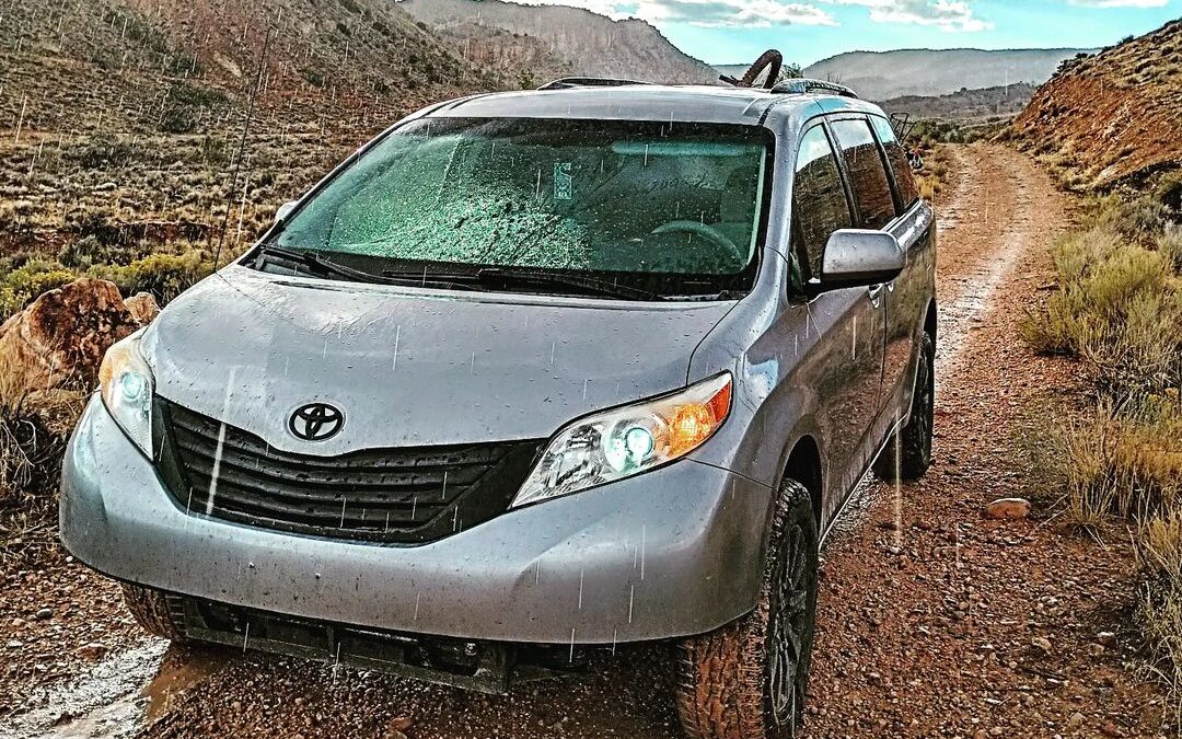 @utsienna Toyota sienna campervan parked on a dirt road on a rainy day
