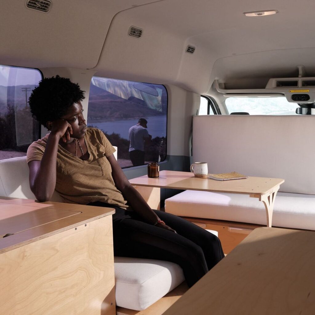 @vanlab_usa van conversion kit, woman sitting inside a campervan