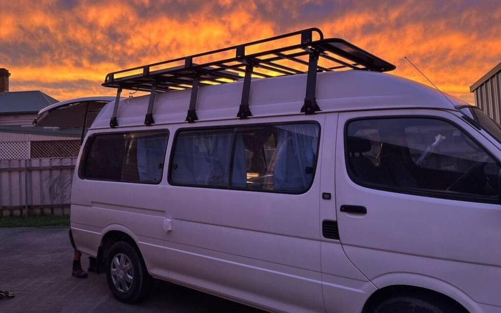 @vanlifewithvinnie Side view of a white camper van with a roof rack