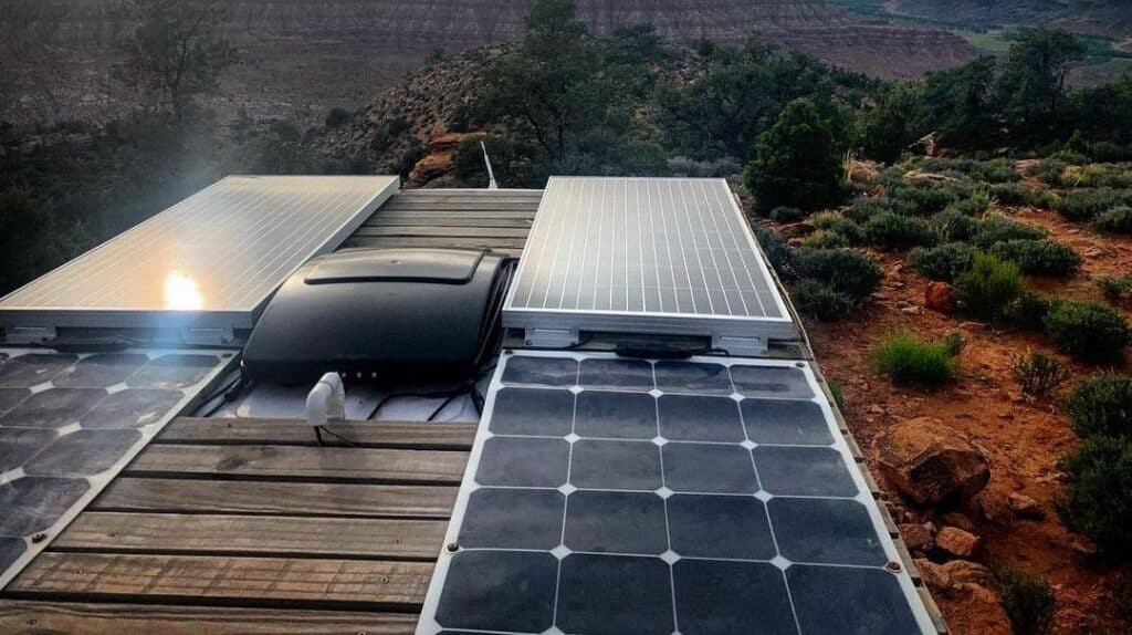 two types of solar panels mounted on van roof with desert scenery in the background